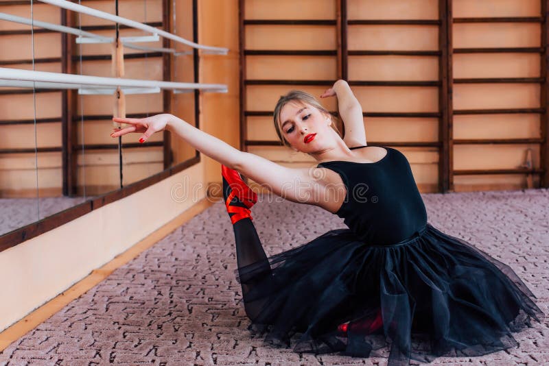 Jonge Glimlachende Ballerina die oefening in opleidingszaal doen stock fotografie Jonge Glimlachende Ballerina die oefening in opleidingszaal doen stock fotografie