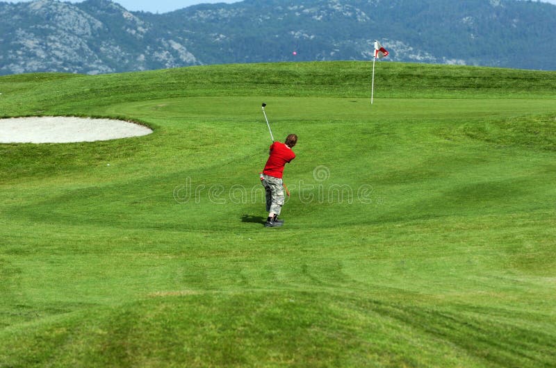 Young men playing golf on a Nice large resort in norway with mountains in the background. Young men playing golf on a Nice large resort in norway with mountains in the background