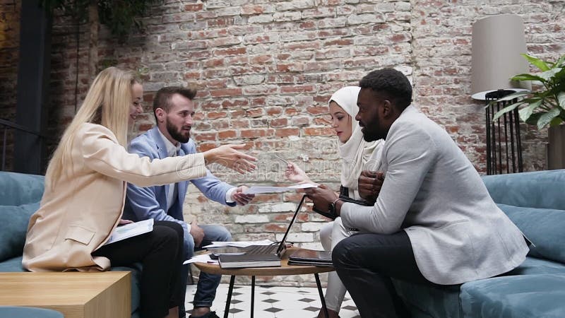 Jonge internationale zakenteams van vier succesvolle mensen bespreken een nieuw project met werkdocument met een tijd