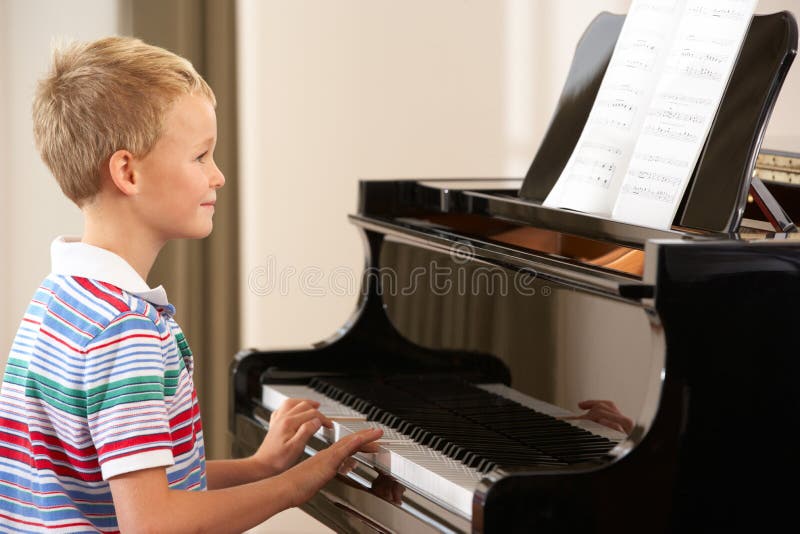 Young boy playing grand piano at home. Young boy playing grand piano at home