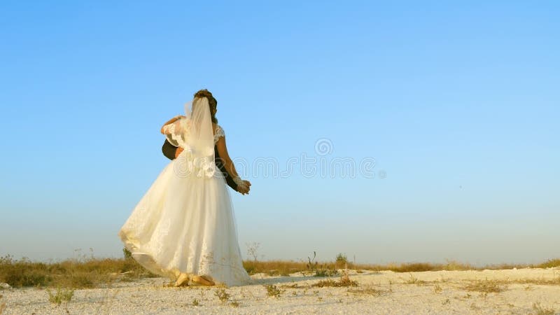 Jonge jongen en meisje dansen in zand en glimlachen elkaar Romantische echtpaar man en vrouw hebben samen plezier tegen elkaar