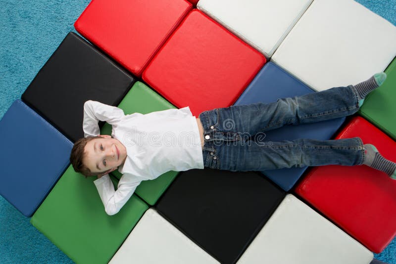 Jonge jongen met wapens achter zijn hoofd, het Glimlachen kind het ontspannen stock foto's Jonge jongen met wapens achter zijn hoofd, het Glimlachen kind het ontspannen stock foto's