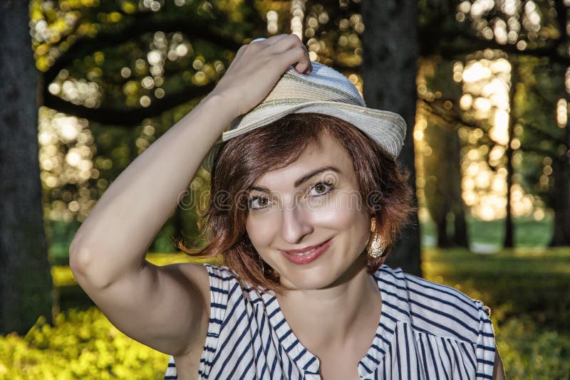 Jonge Kaukasische vrouw met het modieuze sunhat stellen in het bos, royalty-vrije stock foto Jonge Kaukasische vrouw met het modieuze sunhat stellen in het bos, royalty-vrije stock foto