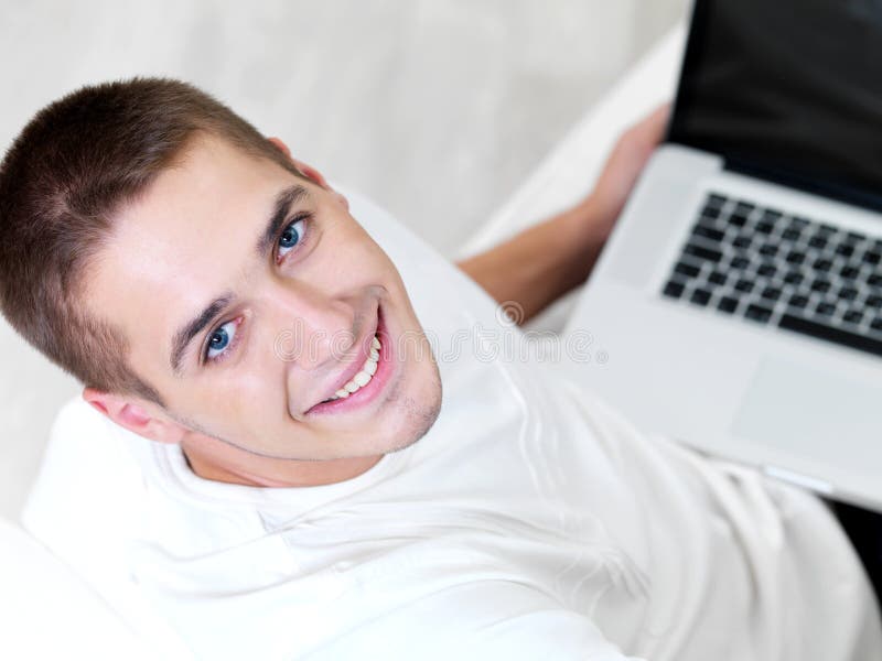 Jonge kerel die laptop met behulp van royalty-vrije stock fotografie Jonge kerel die laptop met behulp van royalty-vrije stock fotografie