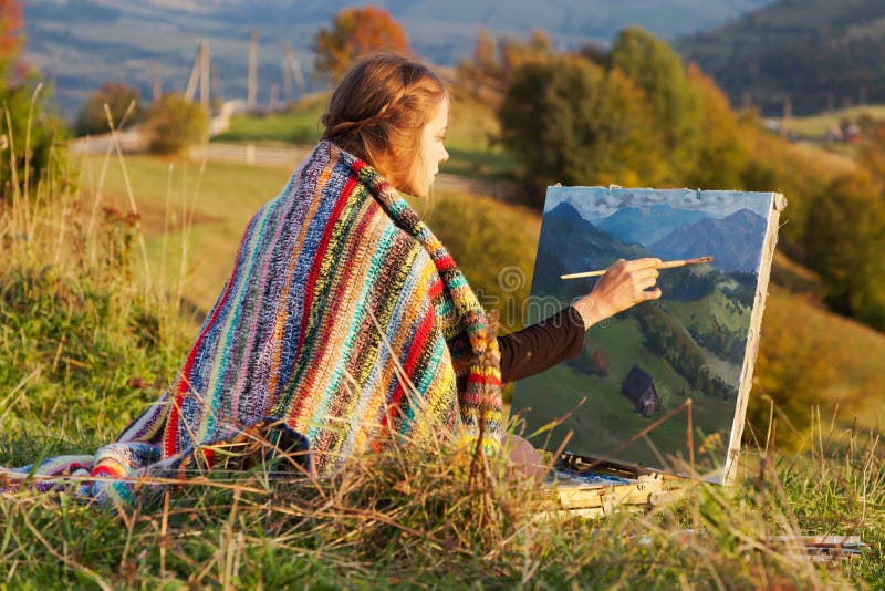 Jonge kunstenaar die een de herfstlandschap schildert