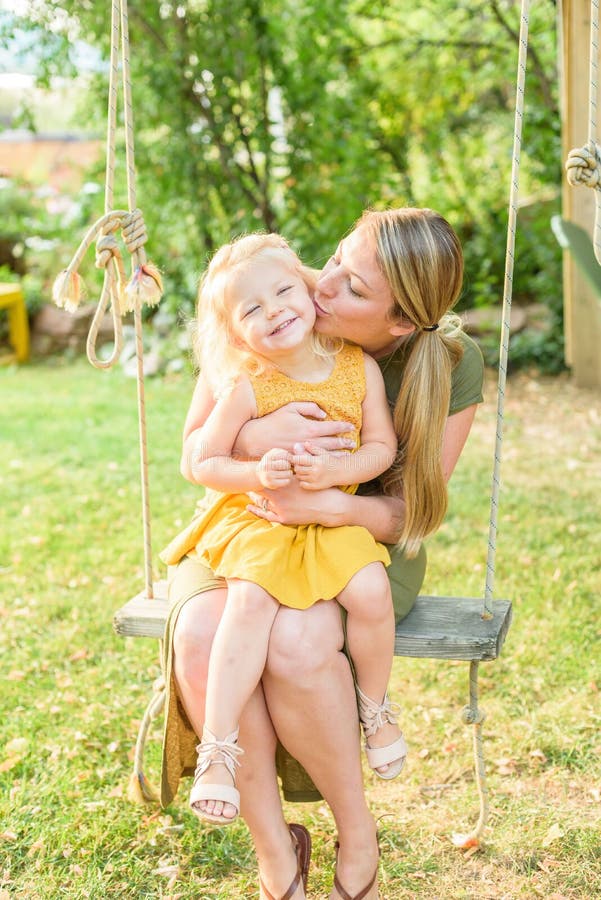Jonge mamma kussende dochter op de wang royalty-vrije stock foto's Jonge mamma kussende dochter op de wang royalty-vrije stock foto's