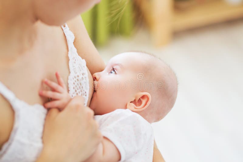 Jonge mammaborst die - haar pasgeboren kind voeden Het concept van de lactatiezuigeling Moedervoer haar babyzoon of dochter met m