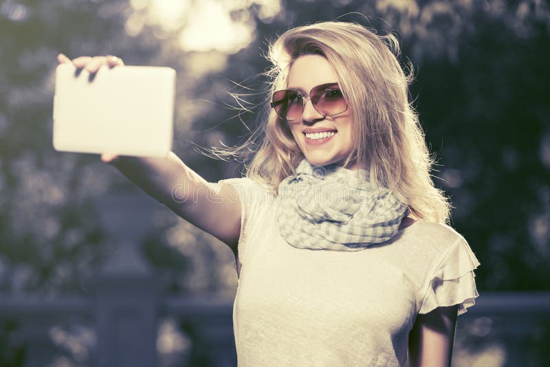 Jonge maniervrouw die een selfie met tabletcomputer nemen openlucht stock fotografie Jonge maniervrouw die een selfie met tabletcomputer nemen openlucht stock fotografie