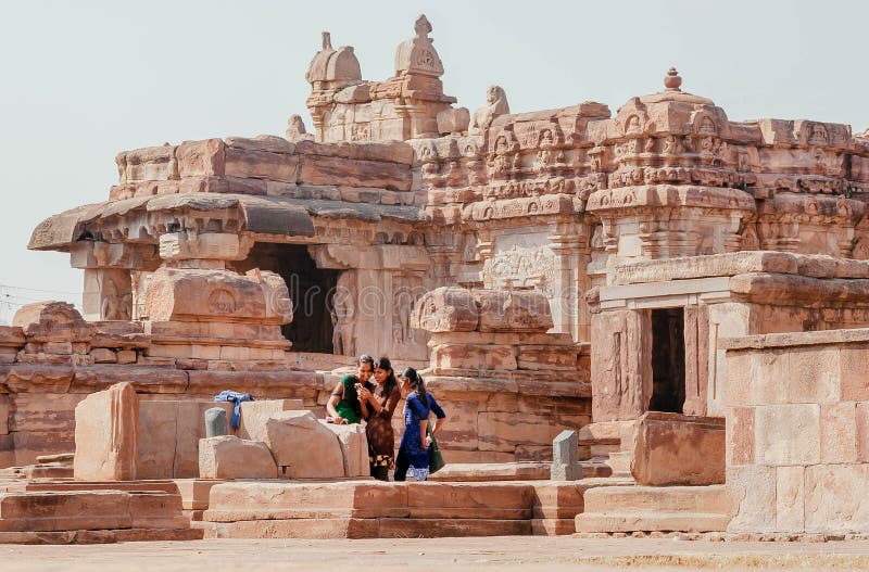 Jonge meisjes die foto's bekijken op de muur van de Hindoe-tempels van de 7e eeuw, India stock fotografie Jonge meisjes die foto's bekijken op de muur van de Hindoe-tempels van de 7e eeuw, India stock fotografie