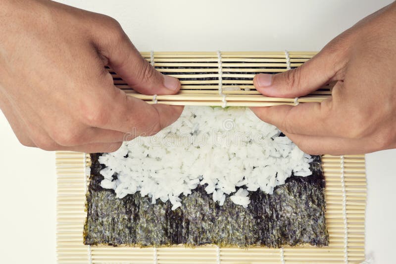 Jonge mens die makizushi voorbereiden royalty-vrije stock afbeelding Jonge mens die makizushi voorbereiden royalty-vrije stock afbeelding