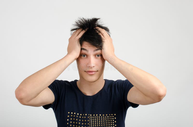 Jonge mens die met gek haar zijn hoofd verward houden. Slechte haardag. royalty-vrije stock afbeelding Jonge mens die met gek haar zijn hoofd verward houden. Slechte haardag. royalty-vrije stock afbeelding