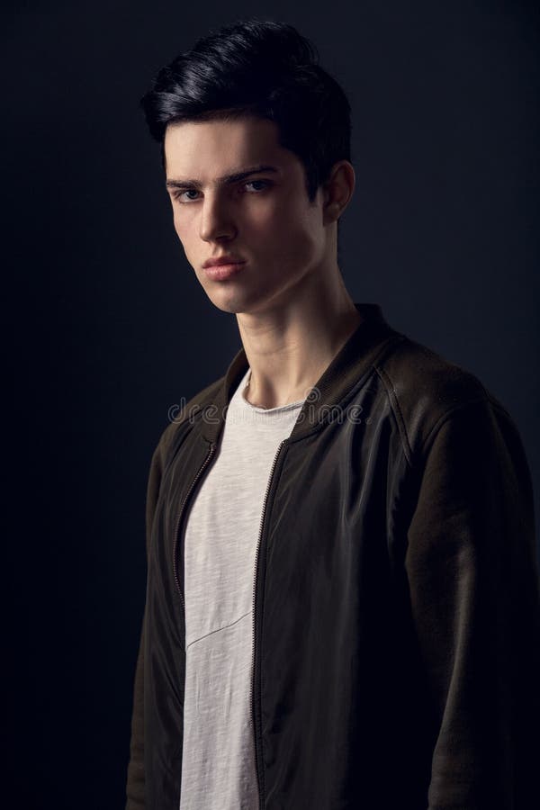 Jonge mens die op een grijs geheimzinnig concept wordt geïsoleerd van de muurstudio stock foto Jonge mens die op een grijs geheimzinnig concept wordt geïsoleerd van de muurstudio stock foto