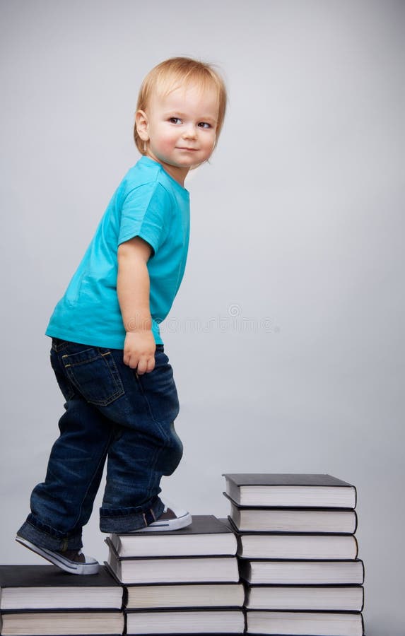 Jonge mens die op een ladder van boeken beklimt stock fotografie Jonge mens die op een ladder van boeken beklimt stock fotografie