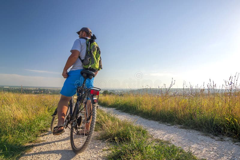 Jonge mens die op fiets in ochtendzonsopgang reizen met prachtig royalty-vrije stock fotografie Jonge mens die op fiets in ochtendzonsopgang reizen met prachtig royalty-vrije stock fotografie