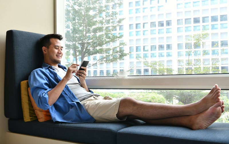 Jonge mens die op mobiele telefoon gebruiken stock afbeeldingen Jonge mens die op mobiele telefoon gebruiken stock afbeeldingen