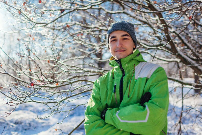 Jonge mens die sportieve kleren in de winter boskerel dragen die camera met gekruiste handen bekijken royalty-vrije stock foto Jonge mens die sportieve kleren in de winter boskerel dragen die camera met gekruiste handen bekijken royalty-vrije stock foto