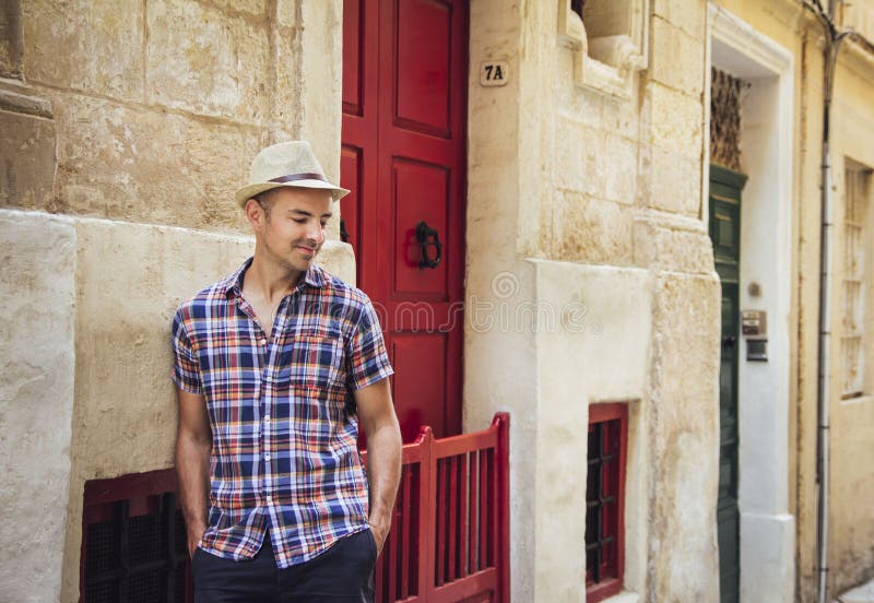Jonge mens die zich in oude straat in Malta bevinden stock afbeelding Jonge mens die zich in oude straat in Malta bevinden stock afbeelding