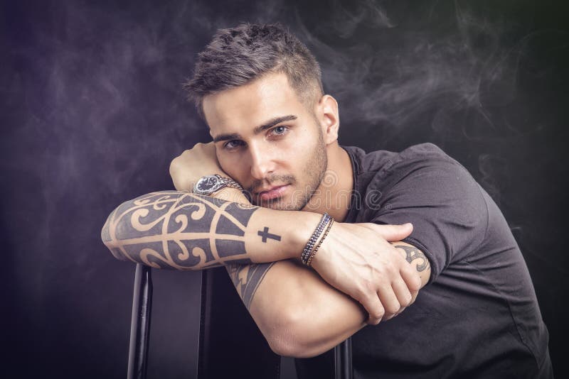 Jonge mens met zwarte t-shirt en tatoegeringen royalty-vrije stock fotografie Jonge mens met zwarte t-shirt en tatoegeringen royalty-vrije stock fotografie