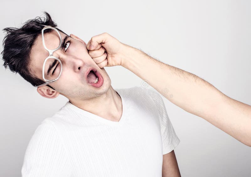 Jonge mens worden die die in de kaak wordt geslagen. stock afbeelding Jonge mens worden die die in de kaak wordt geslagen. stock afbeelding