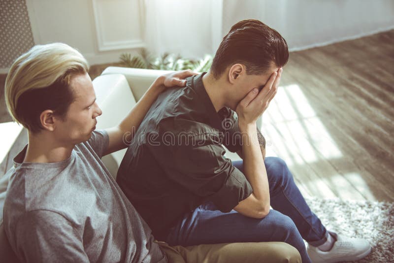 Jonge mensen verbergend gezicht in wapens terwijl vriend wat betreft zijn rug stock afbeelding Jonge mensen verbergend gezicht in wapens terwijl vriend wat betreft zijn rug stock afbeelding