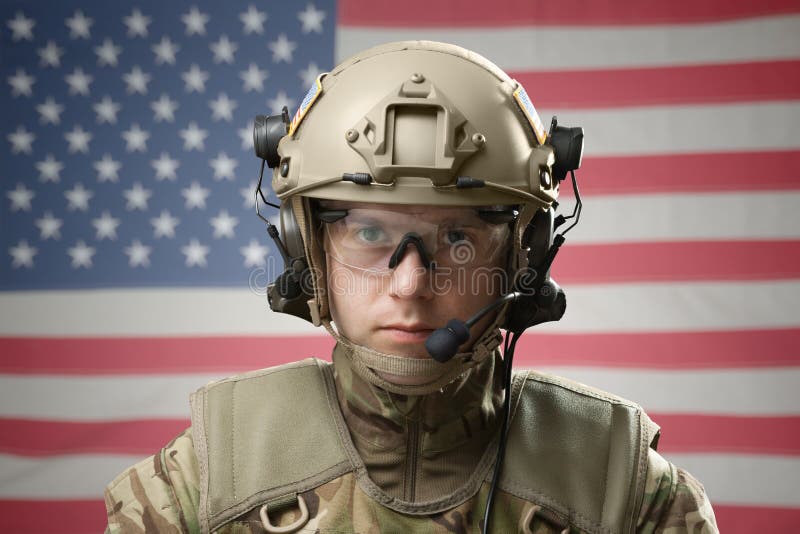 Jonge militaire mens die helm met de vlag van de V.S. op achtergrond dragen stock foto's Jonge militaire mens die helm met de vlag van de V.S. op achtergrond dragen stock foto's