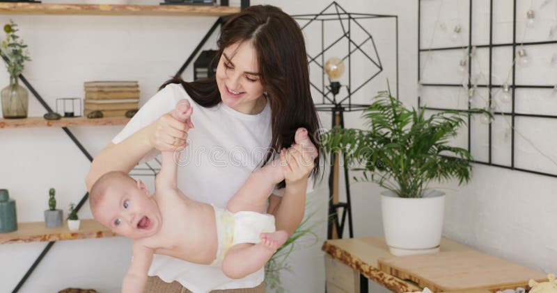 Jonge moeder die haar babybovenkant houden - neer