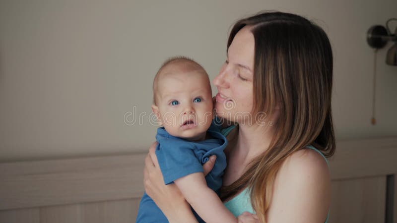 Jonge Moeder die haar Pasgeboren Slaapkind houden De familie thuis, mamma en baby de jongen in slaapkamer, mothe kussen het kusse