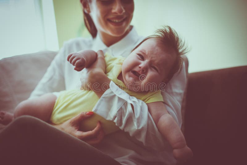 Jonge moeder die haar weinig babymeisje voeden stock fotografie Jonge moeder die haar weinig babymeisje voeden stock fotografie