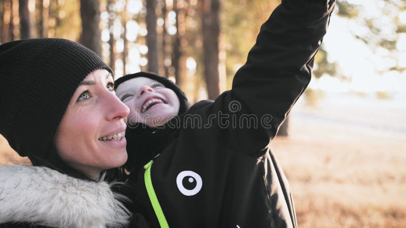 Jonge moeder die met een kleine zoon in het herfstbos loopt.