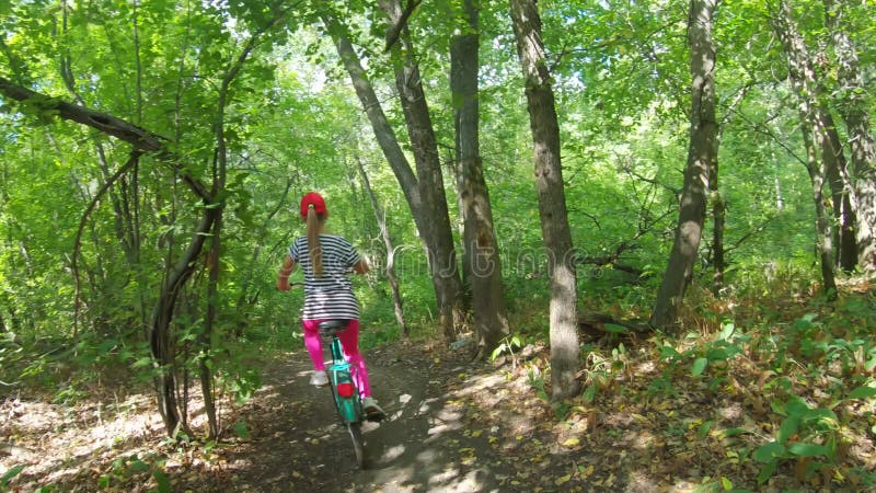 Jonge moeder en dochter met fietsen in het bos.