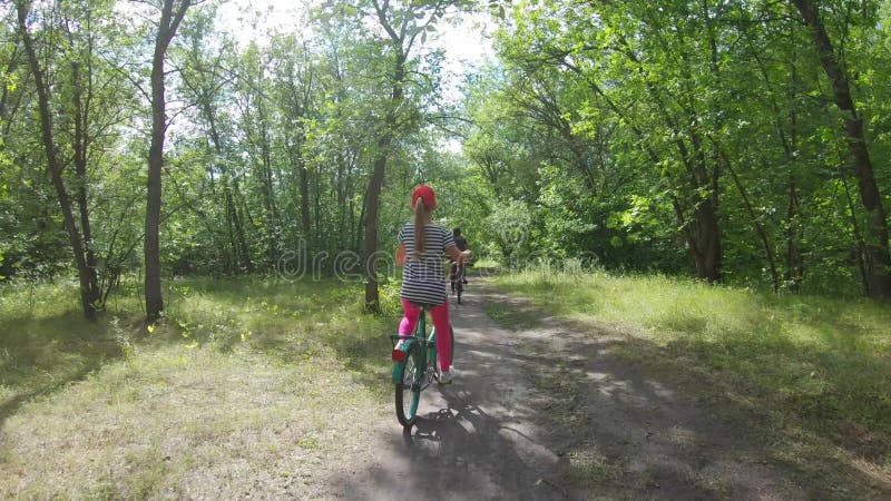 Jonge moeder en dochter met fietsen in het bos.