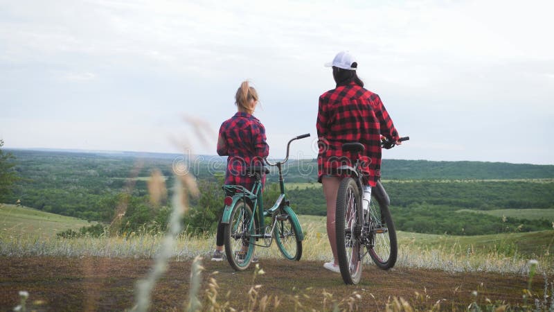 Jonge moeder en dochter met fietsen op de bergen.