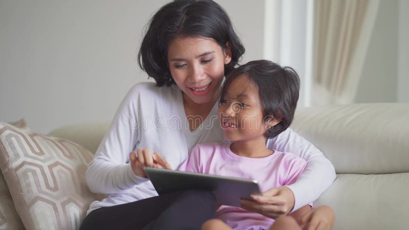 Jonge moeder en haar dochter die tablet gebruiken