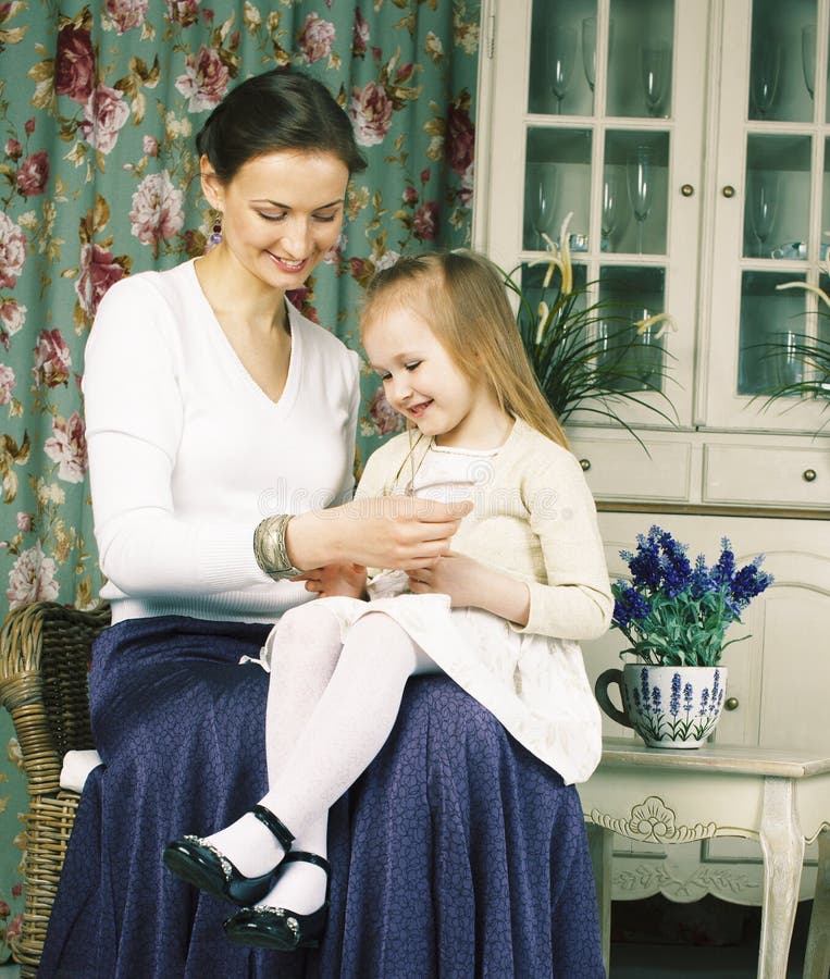Jonge moeder met dochter bij de binnenlandse wijnoogst van het luxehuis royalty-vrije stock foto Jonge moeder met dochter bij de binnenlandse wijnoogst van het luxehuis royalty-vrije stock foto