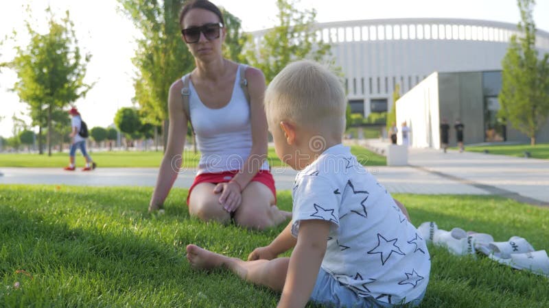 Jonge moeder met haar kleine zoon samen in de zomer in het park