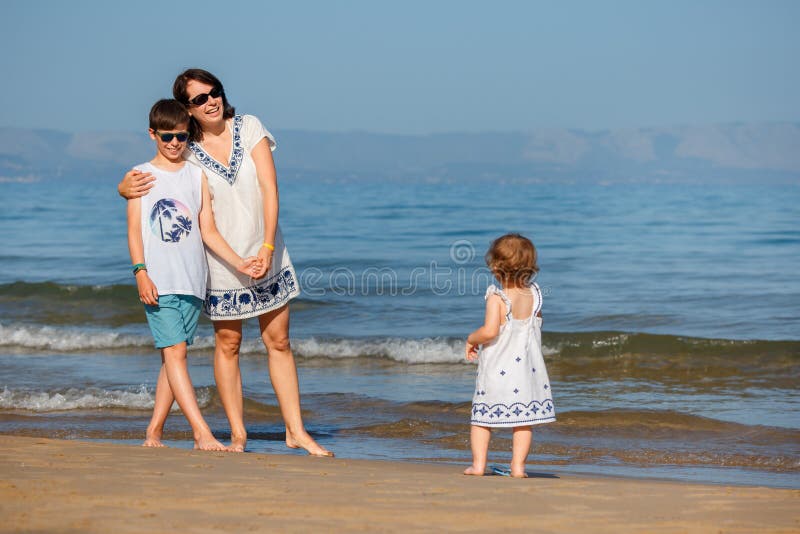 Jonge moeder met haar twee jonge geitjes op tropische strandvakantie royalty-vrije stock foto Jonge moeder met haar twee jonge geitjes op tropische strandvakantie royalty-vrije stock foto
