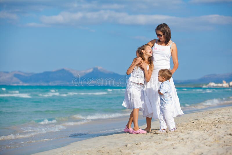 Jonge moeder met haar twee jonge geitjes op strandvakantie royalty-vrije stock foto's Jonge moeder met haar twee jonge geitjes op strandvakantie royalty-vrije stock foto's