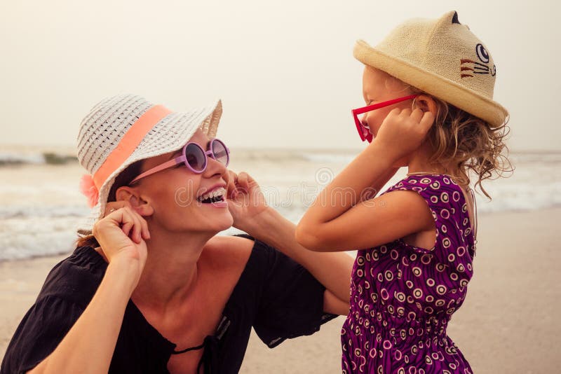 Jonge moeder met klein meisje op haar rug op het strand in de zomer Gelukkige familie met leuke zomervakantie royalty-vrije stock fotografie Jonge moeder met klein meisje op haar rug op het strand in de zomer Gelukkige familie met leuke zomervakantie royalty-vrije stock fotografie