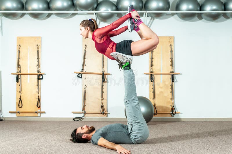 Jonge mooie de training extreme acrobatische oefening van het geschiktheidspaar als voorbereiding voor de concurrentie, selectiev stock afbeeldingen Jonge mooie de training extreme acrobatische oefening van het geschiktheidspaar als voorbereiding voor de concurrentie, selectiev stock afbeeldingen