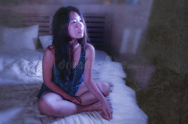 Jonge mooie droevige en ongerust gemaakte Aziatische Koreaanse vrouw wakker bij nacht slapeloos in bed die het nadenkende en pein royalty-vrije stock foto Jonge mooie droevige en ongerust gemaakte Aziatische Koreaanse vrouw wakker bij nacht slapeloos in bed die het nadenkende en pein royalty-vrije stock foto