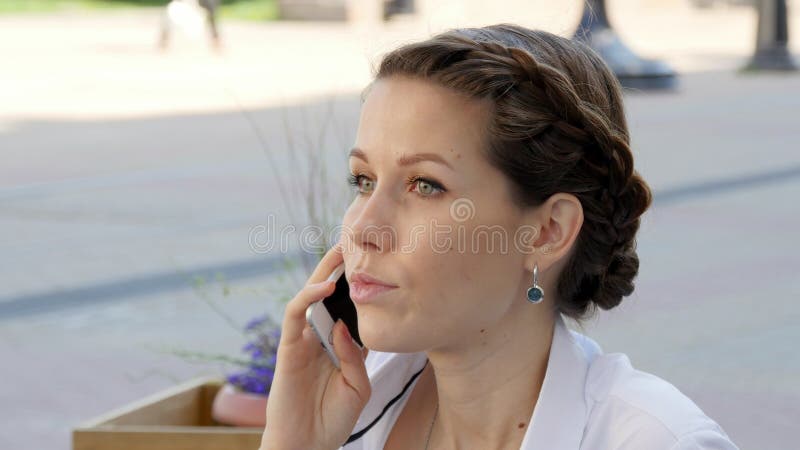 Jonge mooie glimlachende vrouw die op celtelefoon spreken royalty-vrije stock foto's Jonge mooie glimlachende vrouw die op celtelefoon spreken royalty-vrije stock foto's