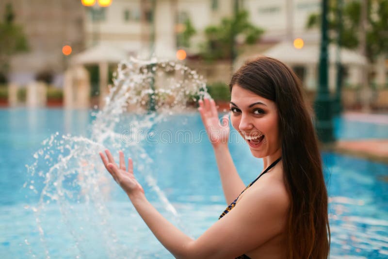 Jonge mooie Kaukasische vrouw die waterplons maken bij de pool die van de zomer genieten Vakantiestemming stock foto's Jonge mooie Kaukasische vrouw die waterplons maken bij de pool die van de zomer genieten Vakantiestemming stock foto's