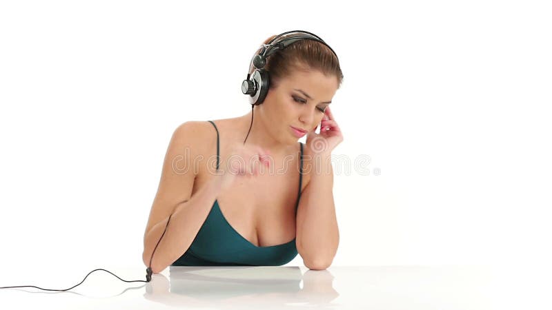 Jonge mooie sexy vrouw het luisteren muziek in grote stereohoofdtelefoons