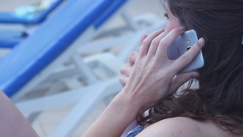Jonge mooie vrouw bij strand beginnend telefoongesprek, gesprek