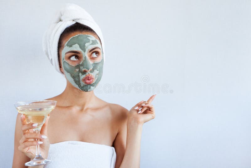Jonge mooie vrouw in gezichtsmasker van therapeutische blauwe modder Kuuroord