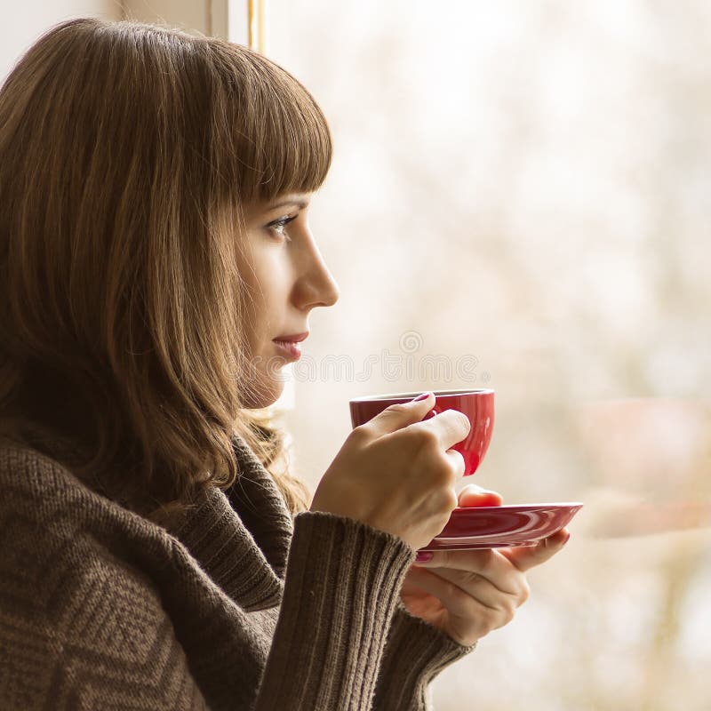 Jonge Mooie Vrouw het Drinken Koffie dichtbij Venster in Koffie stock afbeeldingen Jonge Mooie Vrouw het Drinken Koffie dichtbij Venster in Koffie stock afbeeldingen