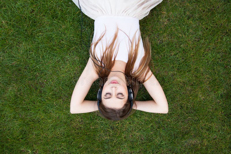 Jonge mooie vrouw het luisteren muziek in hoofdtelefoons stock fotografie Jonge mooie vrouw het luisteren muziek in hoofdtelefoons stock fotografie
