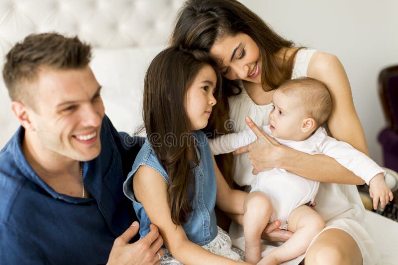 Jonge ouders met dochters in de ruimte stock foto's