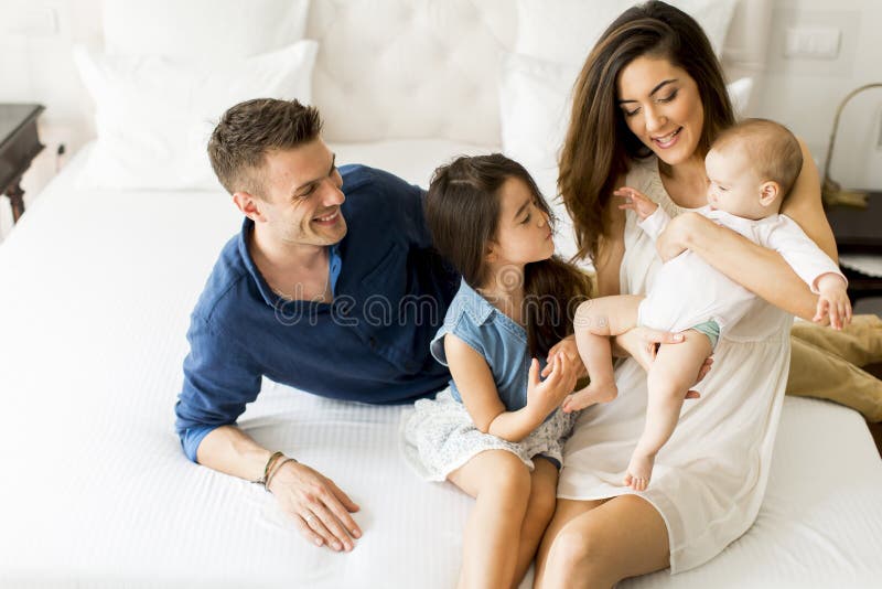 Jonge ouders met dochters in de ruimte stock foto