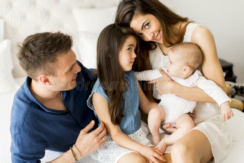 Jonge ouders met dochters in de ruimte stock afbeelding